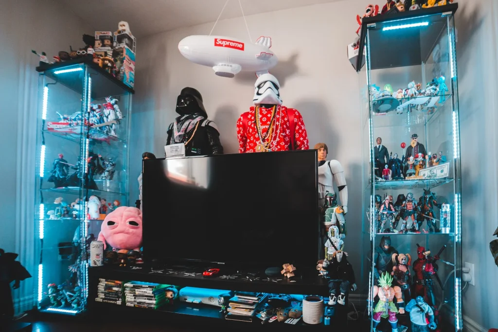 The image showcases a collector's room adorned with an array of pop culture collectibles, including action figures and memorabilia, neatly displayed in glass cabinets and on shelves. The assemblage of items suggests the owner is a passionate enthusiast with a keen interest in geek culture, potentially connected to a "Geekzilla Podcast."





